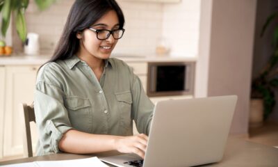 female teenager looking at laptop and making notes